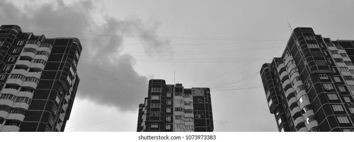 Three dark building on the background of the sky