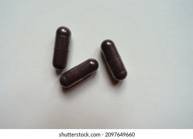 Three Dark Purple Capsules Of Bilberry Extract Dietary Supplement