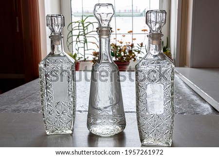 Three decanters of alcohol on the table by the window