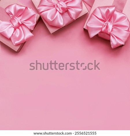 Three decorative gift boxes with pink bows on a pink background with space for text. Top view.