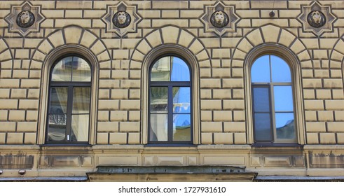 Three Decorative Historic Windows On Beige Walls Building Facade In Saint Petersburg, Russia. Three Simple Arched Windows, Old Classic Exterior Elements Of Historic City House Outdoors