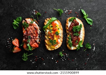 Three delicious colored homemade sandwiches. On a stone background. Top view.