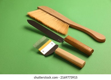 Three Different Beekeeping Tools On Green Background