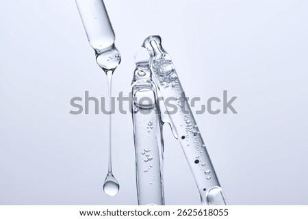 Three different face serum pipettes on a neutral background.