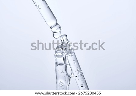 Three different face serum pipettes on a neutral background.