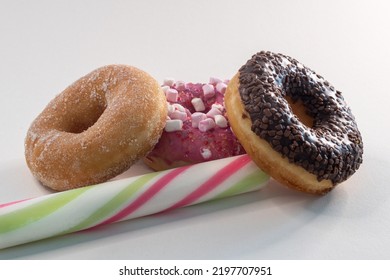 Three different kinds of donuts and a candybar infront