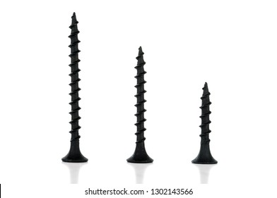 Three different length self-tapping screws are standing upright. Isolated on white background.