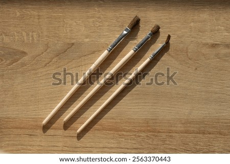 3 paintbrushes laying on a coloured background after finishing painting