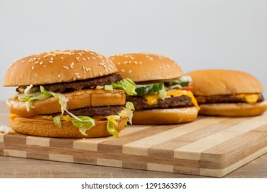 Three different type and size of delicious burgers on a wooden board