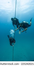 three divers practicing a very safe descent