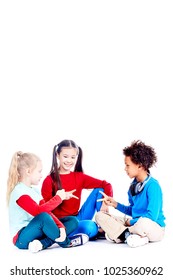 Three Diverse Elementary Students Sitting On Floor And Playing Rock Paper Scissors Game