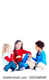 Three Diverse Elementary Students Sitting On Floor And Playing Rock Paper Scissors Game