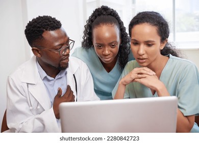 Three doctors look at laptop, serious review of patient case prep surgery - Shutterstock ID 2280842723