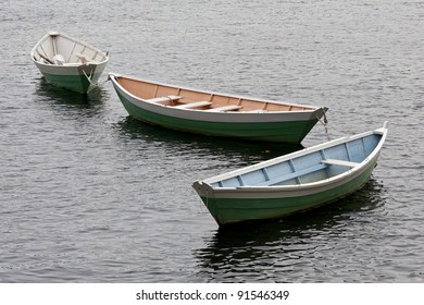 three dory boats tethered in a row