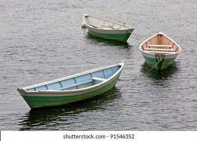 three dory boats tethered in a row