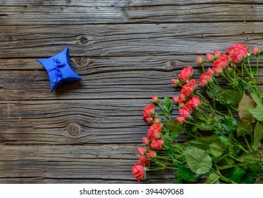 Three Dozen Pink Roses On Stems With Leaves By Coiled Yellow Ribbon And A Couple Of Small Blue Presents