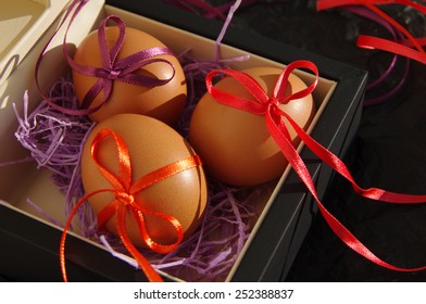 Three Easter eggs with bright tapes in square festive packing