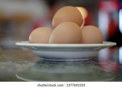 Three eggs on a plate on a table with shallow dept of field - Shutterstock ID 1377692333