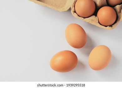 Three eggs out of egg tray isolated on white background. Eggs protected in brown recycle paper tray at ease of use and handle. Top view image with copy space. - Shutterstock ID 1939295518