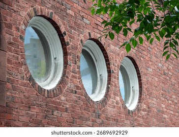 Three elegant circular windows creating a unique architectural feature on a classic brick facade in Boston, Massachusetts, USA