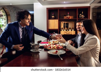 Three Elegantly Dressed Business People Having Dinner And Enjoying Their Free Time