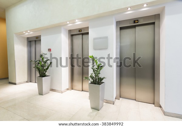 Three elevators in hotel\
lobby