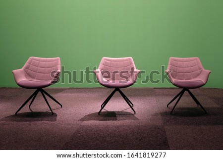 Three empty chairs in a studio with green screen