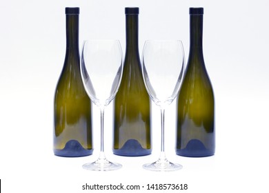 Three empty upturned wine bottles and two glasses on a white background