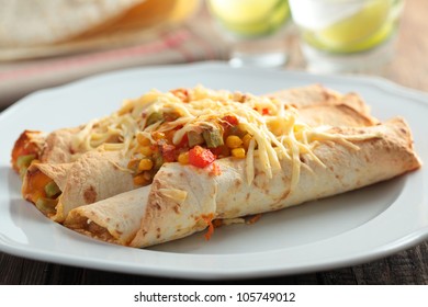 Three Enchiladas On A Rustic Table