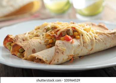 Three Enchiladas On A Rustic Table