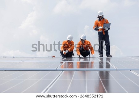 Three engineers checking on solar panel on the rooftop