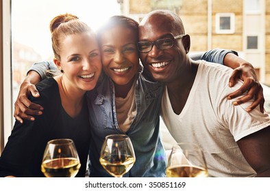 Three Ethnic Best Friends Smiling At Camera And Hugging