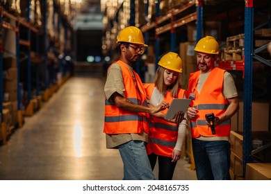 Three factory managers doing a warehouse inspection while using digital tablet and bar code reader - Powered by Shutterstock