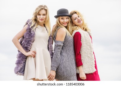 Three fashionable women having presenting pretty stylish outfits. Style, fashion, friendship concept.