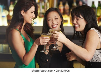 Three Female Friends Enjoying Drink In Cocktail Bar