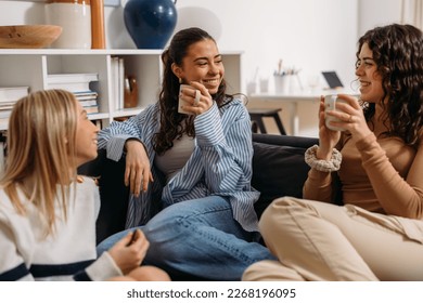 Three female friends are having an enjoyable conversation over coffee - Powered by Shutterstock