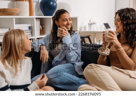 Three female friends are having an enjoyable conversation over coffee