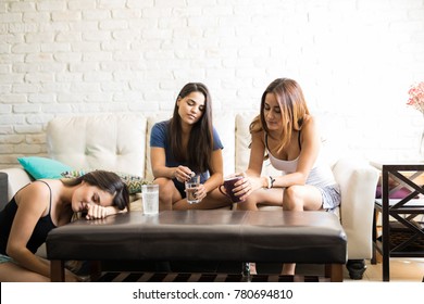 Three Female Friends And Roomates With A Headache And A Hangover After Drinking Too Much