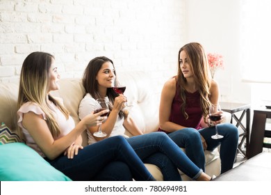 Three Female Roomates Having A Good Time Together And Drinking Some Wine At Home