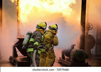 Three firefighters advance with a hose line. - Powered by Shutterstock