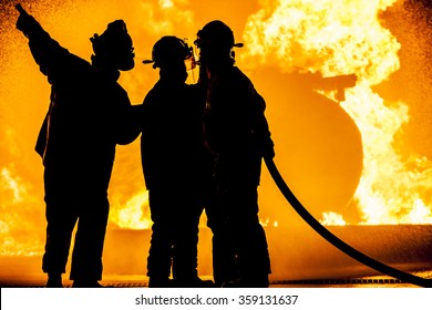 Three Firefighters Fighting A Fire