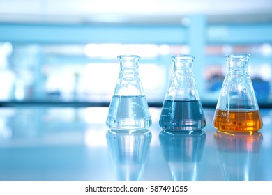 three flask of water black orange solution in science laboratory background - Shutterstock ID 587491055