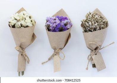 Three Flower Bouquet On White Background. A Bouquet Of Dried Flowers Wrapped In Kraft Paper.