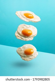 Three flying eggs on the modern blue background, vertical orientation