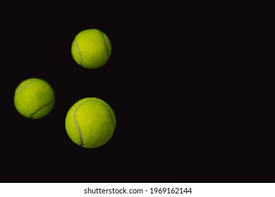 Three Flying Tennis Balls On A Black Background With Copy Space