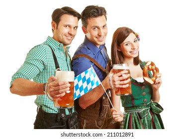 Three Friends In Bavarian Outfit Drinking Beer At Oktoberfest In Bavaria