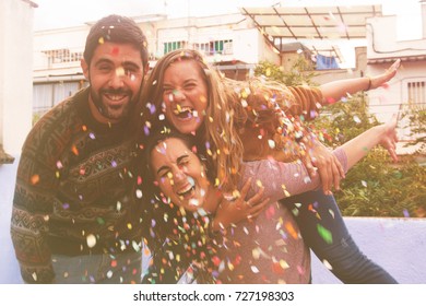 Three Friends Enjoying At Rooftop Party And Throwing Confetti. 