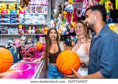 Three friends having fun playing a basketball game at an amusement park, enjoying their summer vacation together