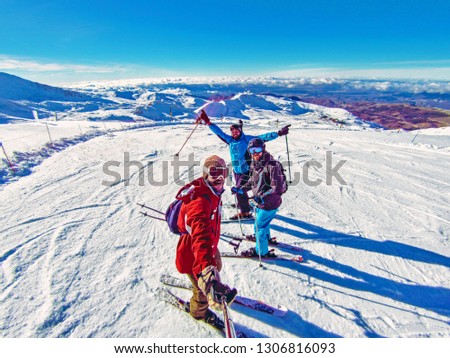 Three friends having fun in Pyrenees, Spain: Ski group of friends taking a fish eye selfie with gopro stick in the mountain top covered in snow after skiing in Spain. Winter sports on holidays, 2019