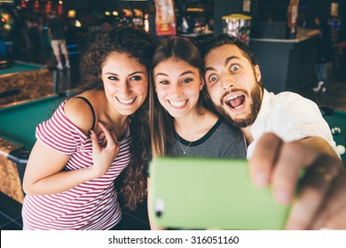 Three Friends Make A Selfie In Playroom